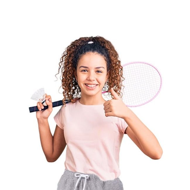 Beautiful kid girl with curly hair holding badminton racket and shuttlecock smiling happy and positive, thumb up doing excellent and approval sign